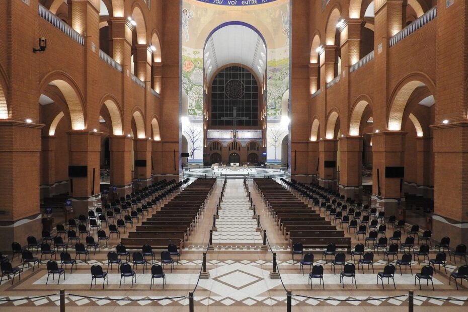 Nave central da Basílica de Nossa Senhora Aparecida, com arcos de tijolos iluminados e fileiras de assentos (SP)
