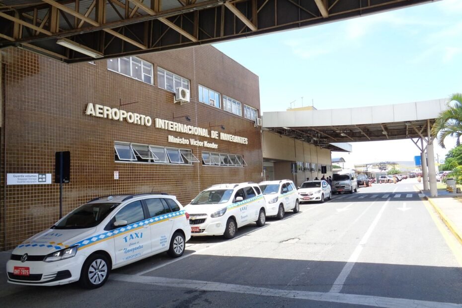 Fachada do Aeroporto Internacional de Navegantes com táxis na entrada, principal acesso aéreo a Balneário Camboriú (SC)