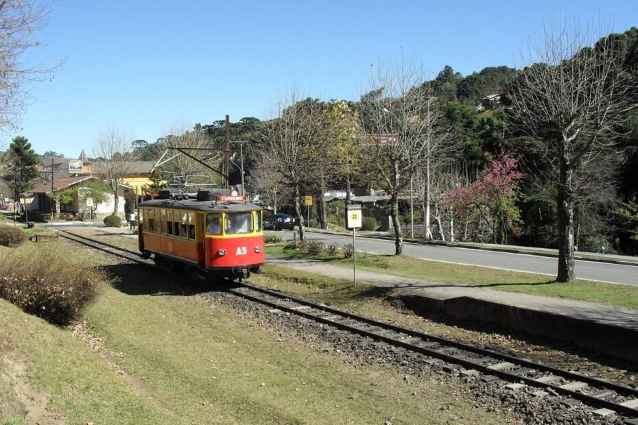 Bondinho vermelho e amarelo da Estrada de Ferro Campos do Jordão sobre os trilhos, na Serra da Mantiqueira (SP)