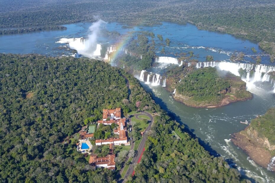 Vista aérea das Cataratas do Iguaçu e do Hotel das Cataratas cercados pela mata, em Foz do Iguaçu