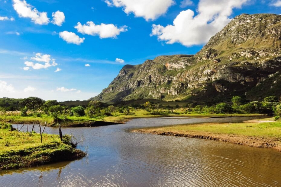 Lago da Lapinha da Serra com a serra rochosa ao fundo sob céu azul, na Serra do Cipó (MG)