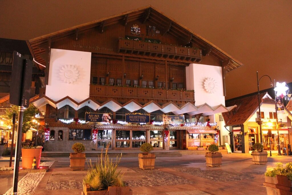Fachada do Palácio dos Festivais à noite com enfeites natalinos e placa da bilheteria do Natal Luz, em Gramado
