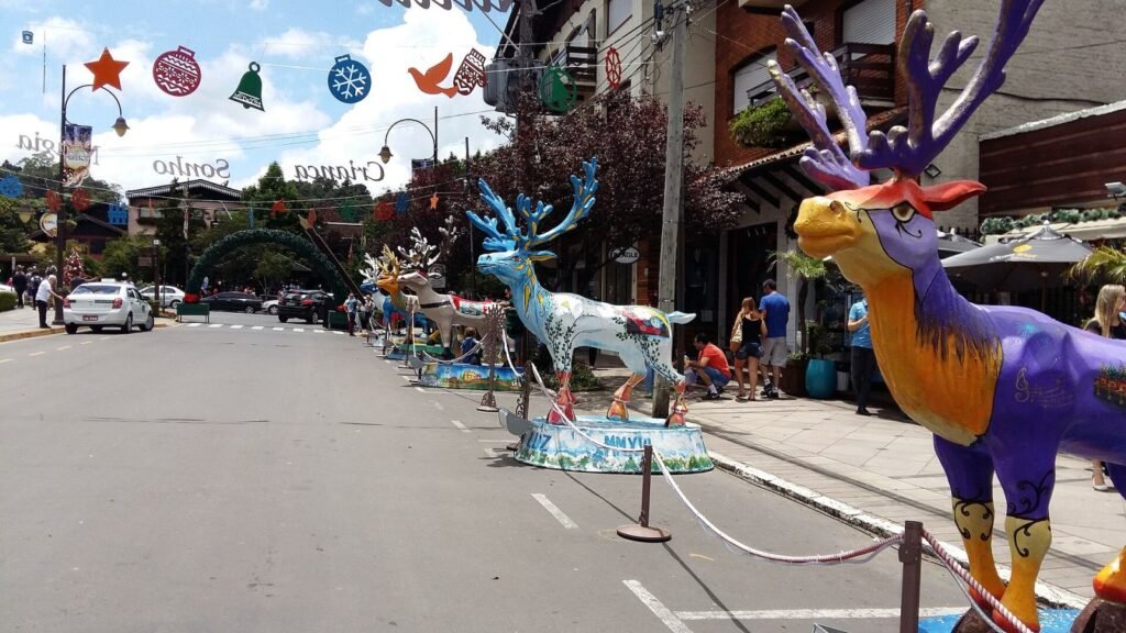 Esculturas de renas coloridas enfileiradas em rua decorada para o Natal em Gramado (RS)