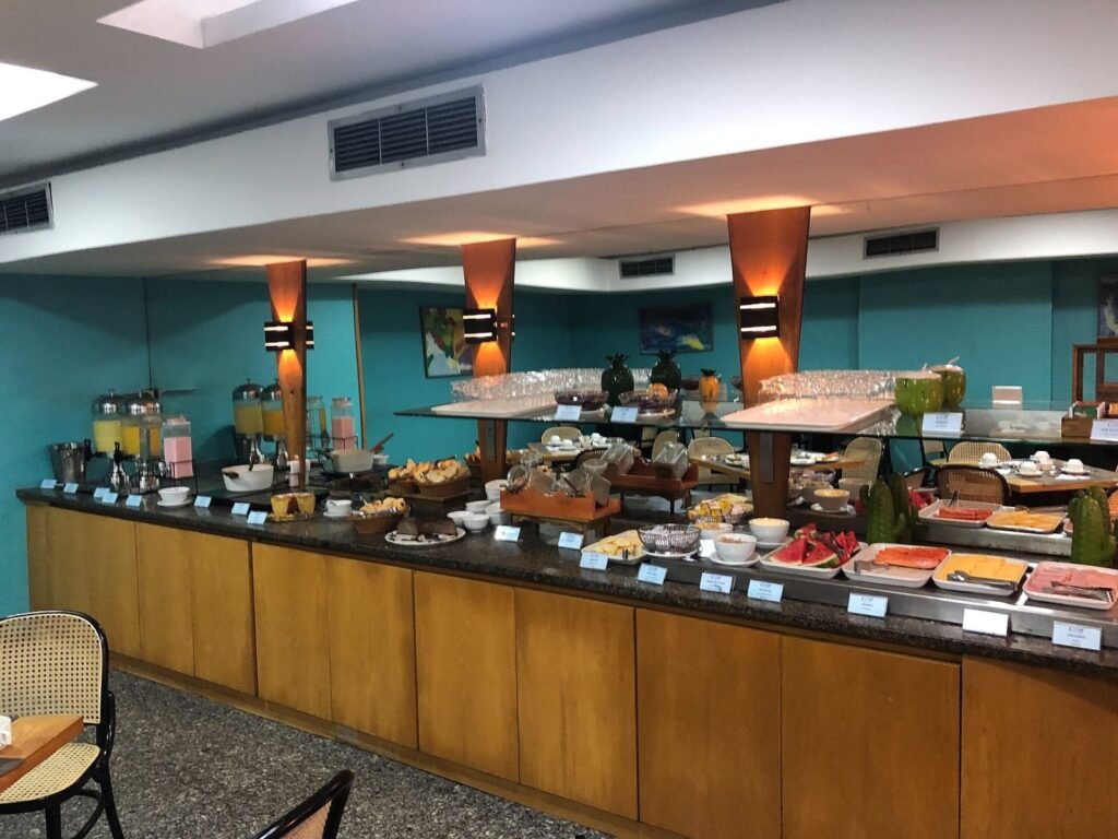 Buffet de café da manhã de hotel com frutas, sucos, pães, bolos e frios, no Brasil
