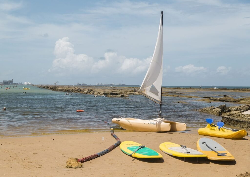 Caiaque, pranchas de stand up paddle e barco a vela na areia da Praia de Muro Alto, em Ipojuca (PE)