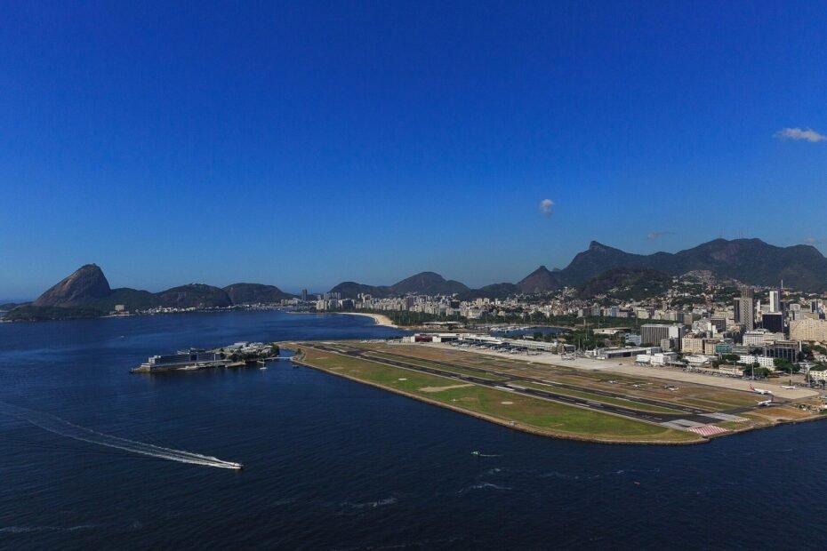Vista aérea do Aeroporto Santos Dumont na Baía de Guanabara, com o Pão de Açúcar ao fundo, Rio de Janeiro