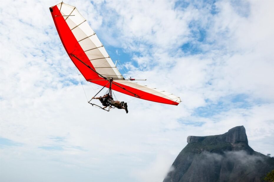 Voo de asa-delta saindo da Pedra Bonita, com a Pedra da Gávea entre nuvens, no Rio de Janeiro