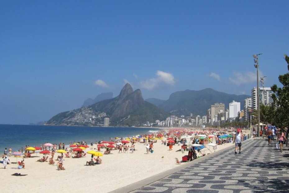 Praia de Ipanema com guarda-sóis em dia ensolarado e o Morro Dois Irmãos ao fundo, Rio de Janeiro